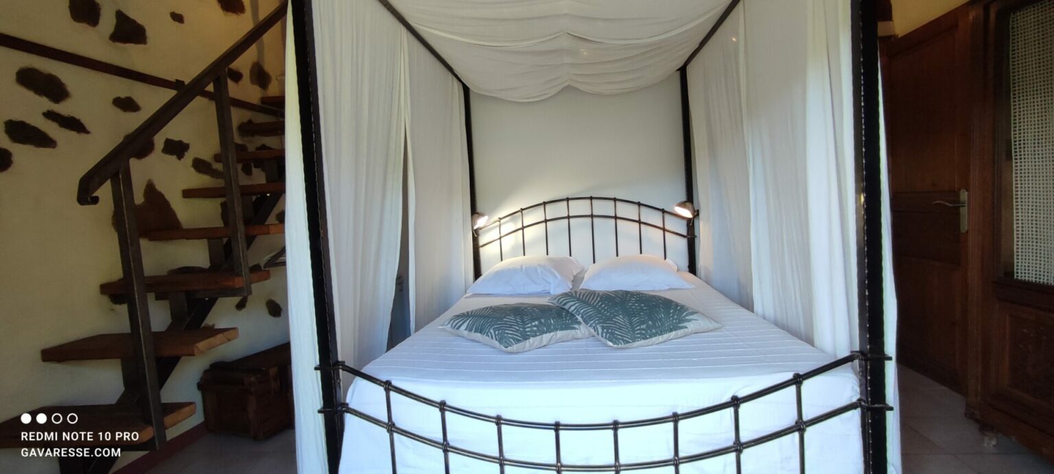 Lit à baldaquin Chambre 4 Gîte La Fenière Le Pradet rideaux fermés
