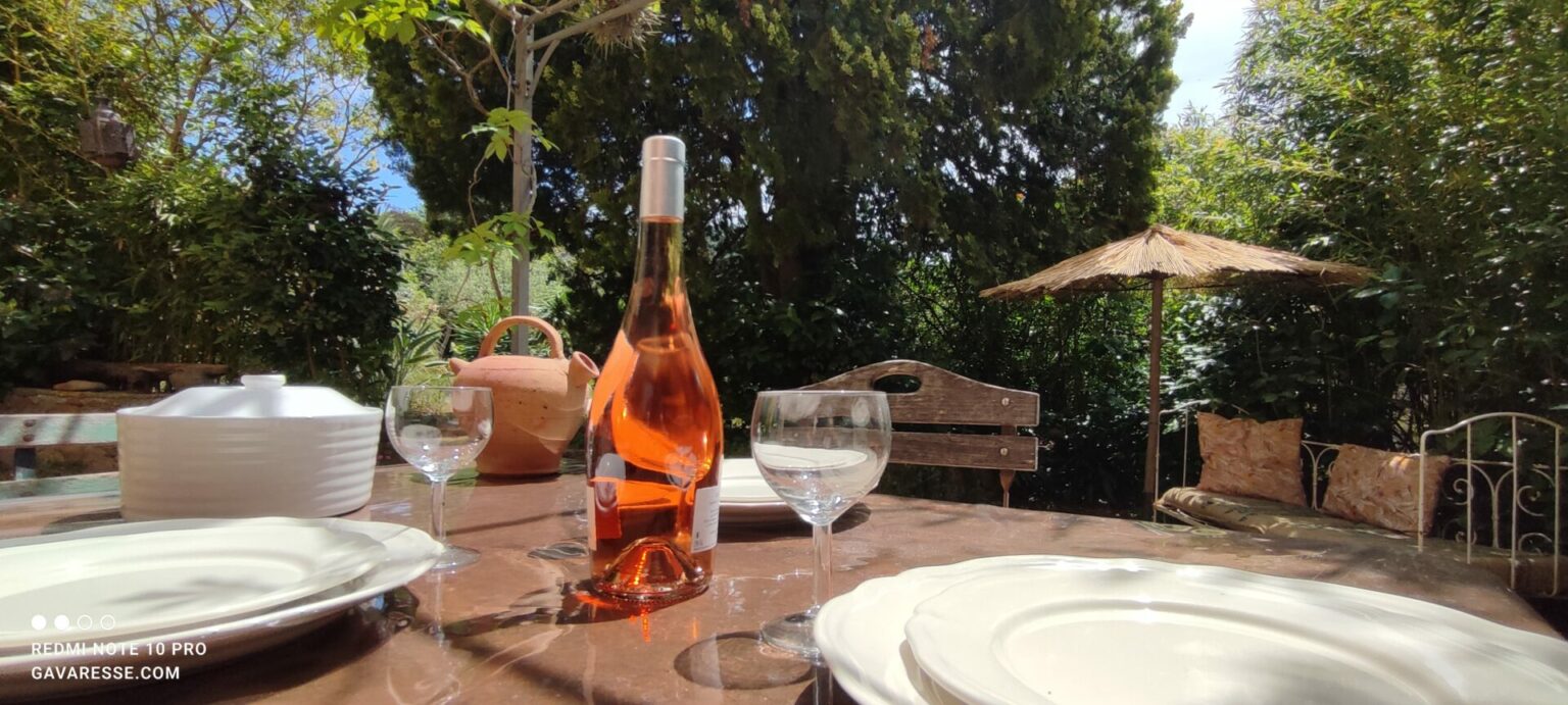 Große Holztafel auf der schattigen Terrasse des Mas de la Gavaresse, gedeckt für ein Gruppenessen in Le Pradet