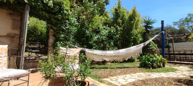 Boho-style hammock in the lush green garden at Mas de la Gavaresse charming holiday home in Le Pradet.