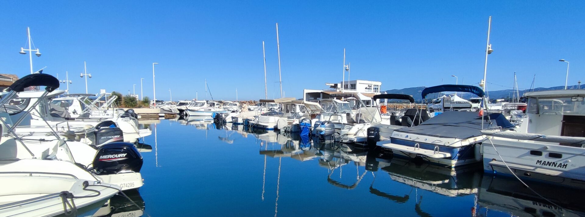 Boats moored at Port des Oursinières in Le Pradet under a blue sky near La Gavaresse group guesthouse.