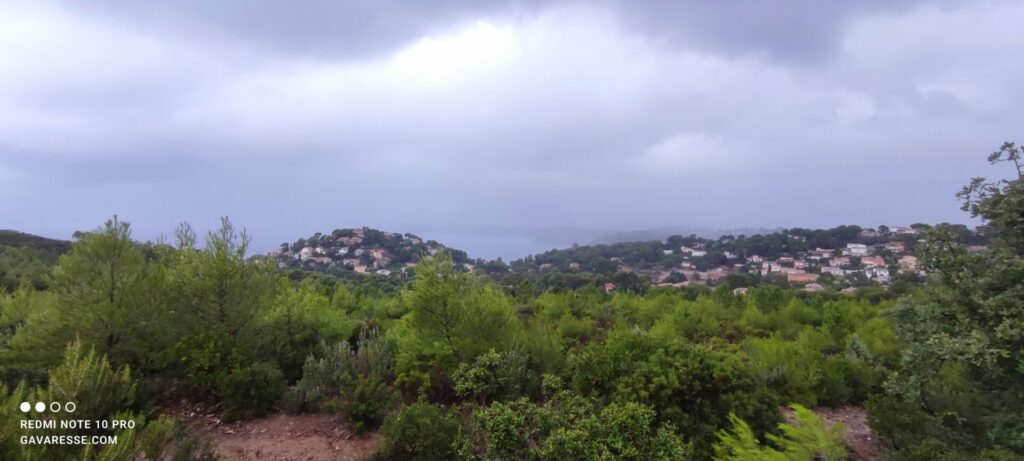 Panorama depuis les collines du Pradet montrant la végétation méditerranéenne sous un ciel gris et nuageux.